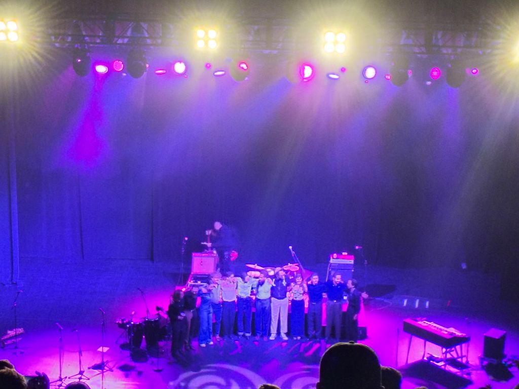 Thee Sacred Souls members on stage embracing